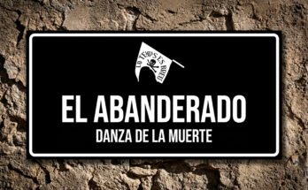 Placa estilo cartel de calle con el icono de una bandera con calavera, símbolo del Abanderado de la procesión de Verges.