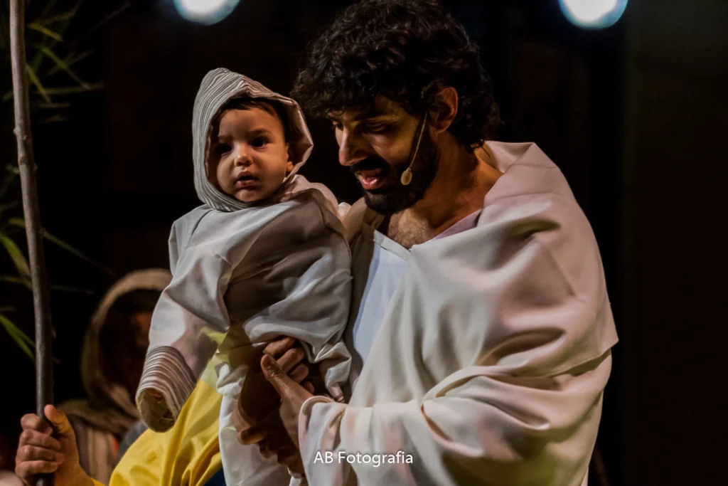 Una curiositat de la casa: En una de les escenes més recordades a la Plaça, durant l'Entrada a Jerusalem (el Ram), es va poder veure a Jesús entrant amb un nadó en braços. No era un recurs d'atrezzo: era el propi fill de l'actor, que havia nascut feia pocs mesos. Un moment real que demostra com Verges viu la seva Processó com una herència que passa de pares a fills.