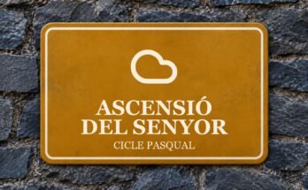 Rètol ocre sobre un mur de pissarra amb un pictograma i el text «ASCENSIÓ DEL SENYOR».
