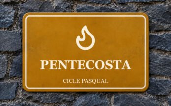 Rètol ocre sobre un mur de pissarra amb un pictograma i el text «PENTECOSTA».