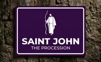 White figure of Saint John with a staff on a purple sign reading “Saint John · The Procession”.