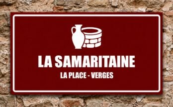 Cruche blanche près d'un puits sur un panneau rouge «La Samaritaine · La Place, Verges».