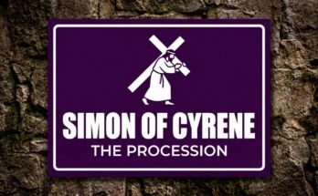 White figure of Simon of Cyrene helping carry the cross on a purple sign.