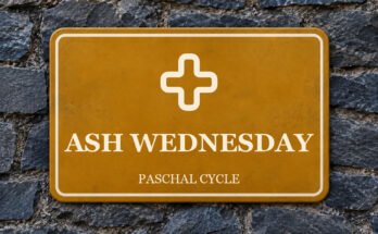 Ochre sign on a slate wall with a pictogram and the words “ASH WEDNESDAY”.