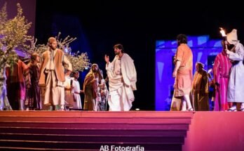 Escena de la representación de la Pasión en la plaza de Verges con actores y escenografía iluminada.