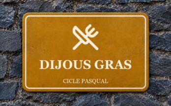 Rètol ocre sobre un mur de pissarra amb un pictograma i el text «DIJOUS GRAS».