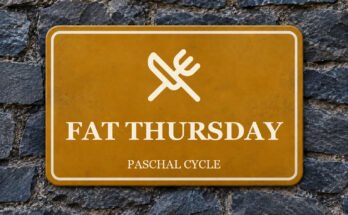 Ochre sign on a slate wall with a pictogram and the words “FAT THURSDAY”.