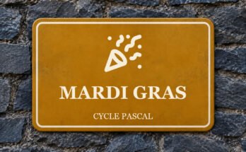 Panneau ocre sur un mur d’ardoise, avec un pictogramme et le texte «MARDI GRAS».