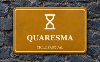 Rètol ocre sobre un mur de pissarra amb un pictograma i el text «QUARESMA».
