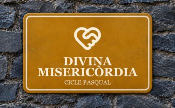Rètol ocre sobre un mur de pissarra amb un pictograma i el text «DIVINA MISERICÒRDIA».