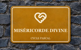 Panneau ocre sur un mur d’ardoise, avec un pictogramme et le texte «MISÉRICORDE DIVINE».