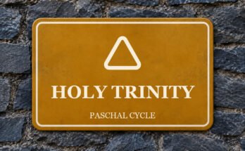 Ochre sign on a slate wall with a pictogram and the words “HOLY TRINITY”.
