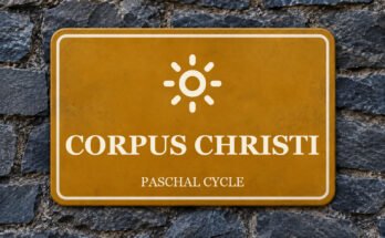 Ochre sign on a slate wall with a pictogram and the words “CORPUS CHRISTI”.