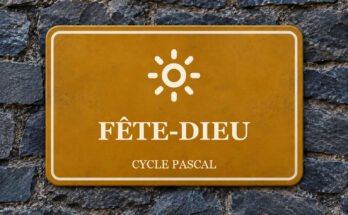 Panneau ocre sur un mur d’ardoise, avec un pictogramme et le texte «FÊTE-DIEU».