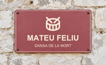 Rètol rosa sobre un mur de pedra calcària amb el text «MATEU FELIU» i un pictograma.