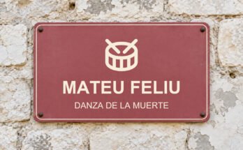 Rótulo rosa sobre un muro de piedra caliza con el texto «MATEU FELIU» y un pictograma.