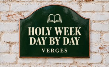 Arched green sign reading “HOLY WEEK DAY BY DAY”, with an open book, on a whitewashed brick wall.