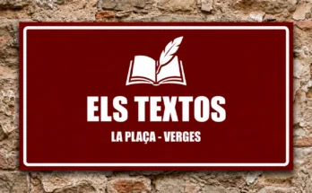 Rètol vermell amb un llibre i una ploma blancs i el text «Els textos · La Plaça - Verges», sobre un mur de pedra.